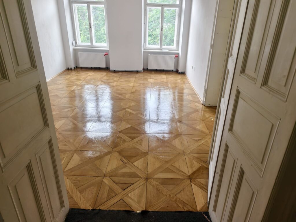 Saniertes Tafelparkett direkt nach dem Auftrag der zweiten seidenmatten Lackschicht, Altbau Graz