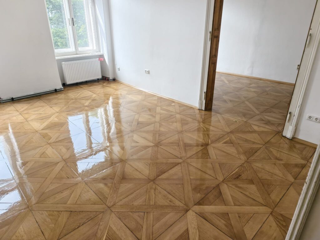 Saniertes Tafelparkett nach Grob-, Mittel- und Feinschliff mit seidenmatter Lackversiegelung, Altbau Graz