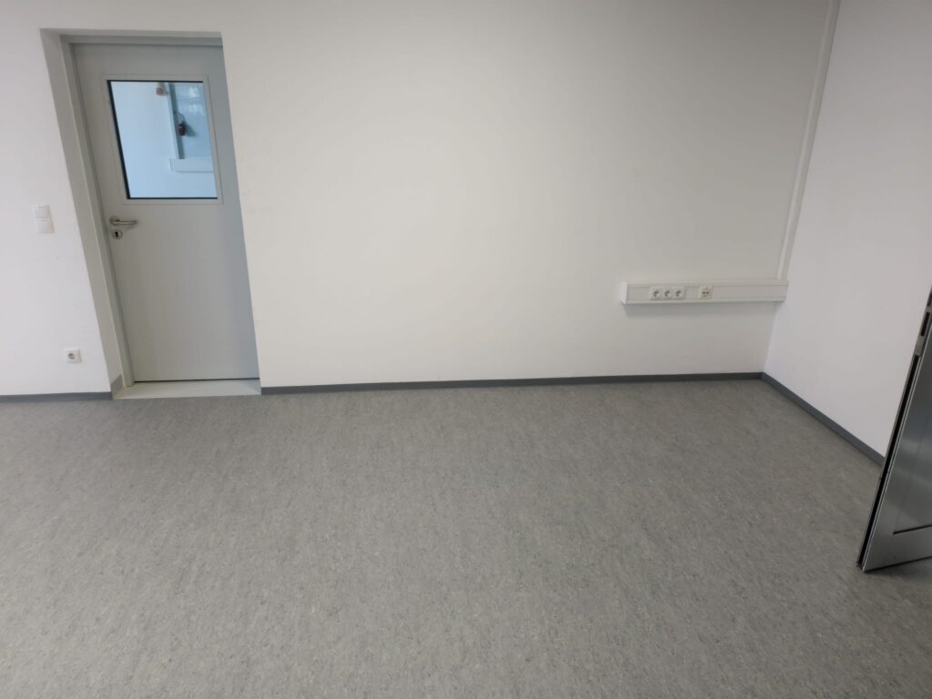 Fertig verlegter Linoleumboden mit sauber montierten grauen PVC-Randleisten, MAGNA Ilz